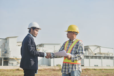 Young man wearing hat standing at construction site