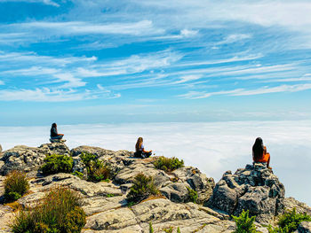 People looking at mountain against sky
