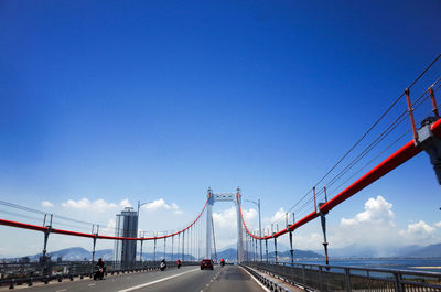 View of suspension bridge against blue sky
