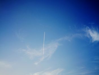 Low angle view of vapor trail against blue sky