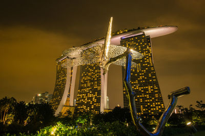 Low angle view of sculpture against marina bay sands in city at night