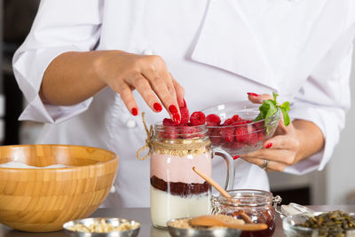 Midsection of chef preparing food in commercial kitchen