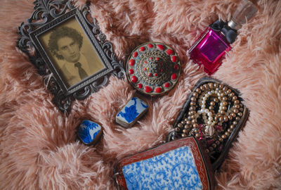 High angle view of treasure boxes, pearl jewelry, perfume bottle and photo of son in mother room