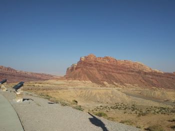 Scenic view of arid landscape against clear blue sky