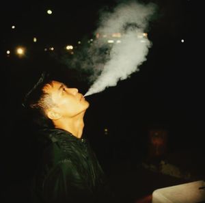 Man smoking against black background