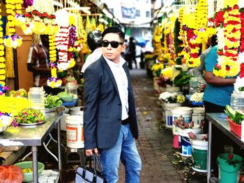 Businessman wearing sunglasses standing in street market