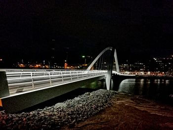 Illuminated bridge against sky at night