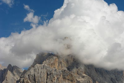 Low angle view of clouds over mountain against sky