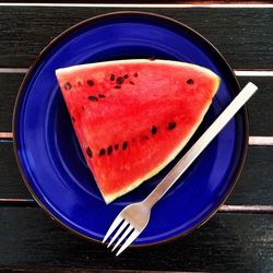 High angle view of watermelon slice in blue plate on table