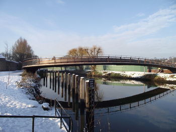 Bridge over river against sky during winter