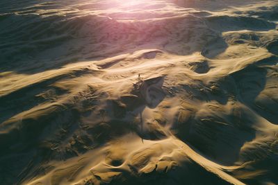 High angle view of person on sand dune in desert during sunset