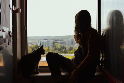 Rear view of woman sitting at home