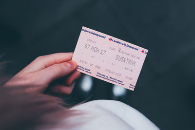 Close-up of hand holding paper with text