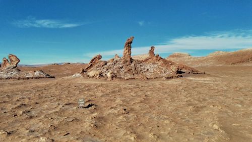 Scenic view of desert land against blue sky