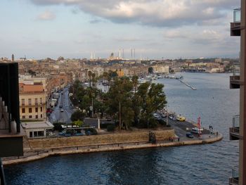 River amidst buildings in city against sky