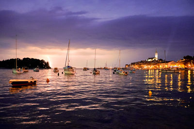 Sailboats in sea at sunset