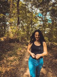 Portrait of smiling young woman in forest