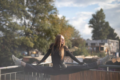 Low angle view of woman standing against railing