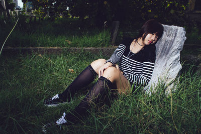 Rear view of woman sitting on field