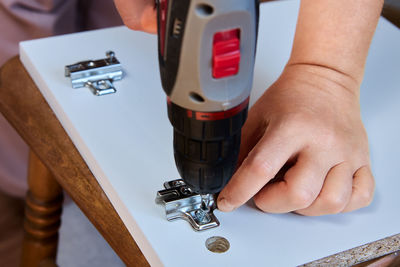 Cropped hands of man repairing machine part