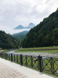 Scenic view of river by mountains against sky