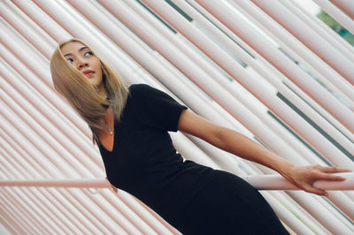 Woman looking away while standing by railing