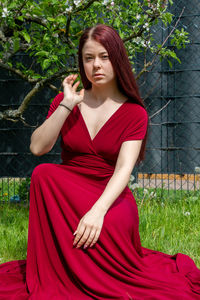 Portrait of young woman sitting on field