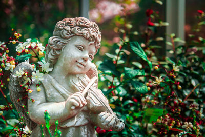 Close-up of angel statue against plants