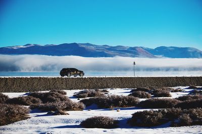 Scenic view of snowcapped mountains against blue sky