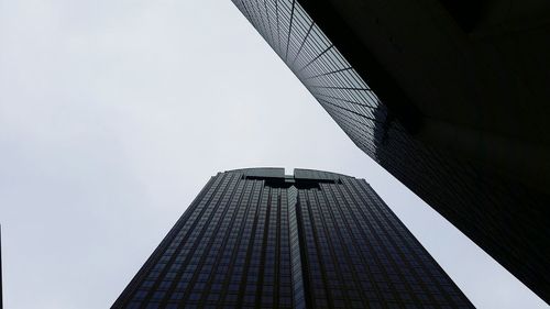 Directly below view of office skyscraper against clear sky