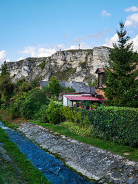 House amidst trees and buildings against sky