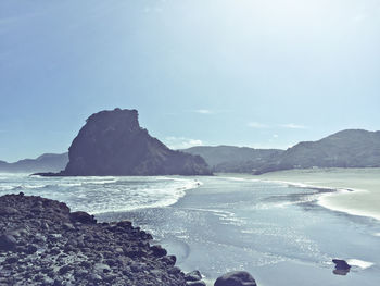 Scenic view of sea and mountains against sky