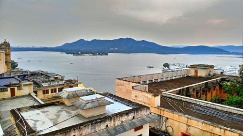 High angle view of town by sea against sky