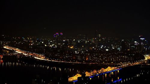 Illuminated cityscape against sky at night