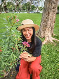 Portrait of young woman standing against plants