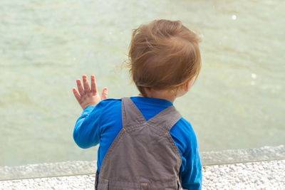 Young boy staring out into the water 