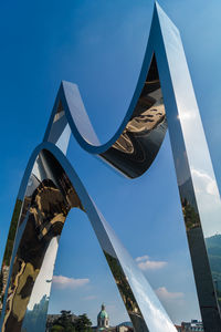 Low angle view of flags against blue sky