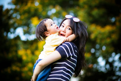 Rear view of mother and daughter against trees