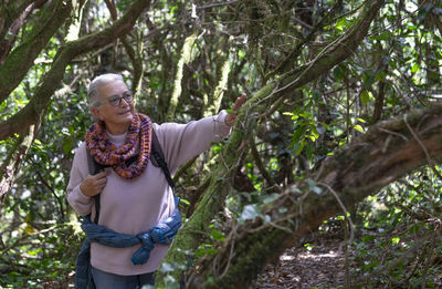 Senior woman standing in forest