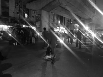 People walking on illuminated city at night