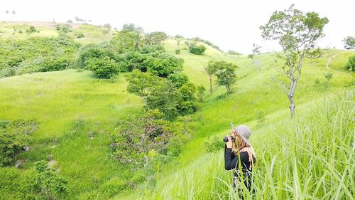 Side view of woman photographing landscape