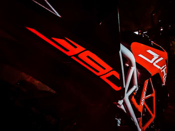 Close-up of arrow sign on road at night