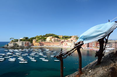 Buildings by sea against clear blue sky