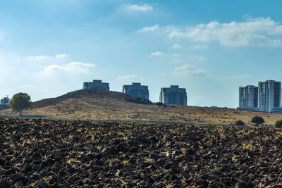 Buildings on field against sky