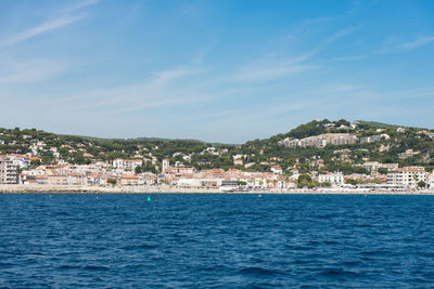 View of townscape by sea against sky