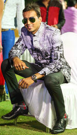 Young man wearing sunglasses sitting outdoors