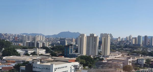 Buildings in city against clear sky