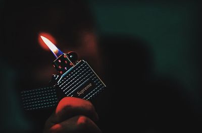 Close-up of hand holding lit candle