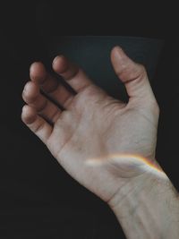 Cropped image of hand against black background