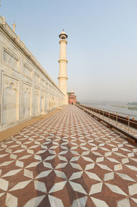 View of tower by sea against clear sky